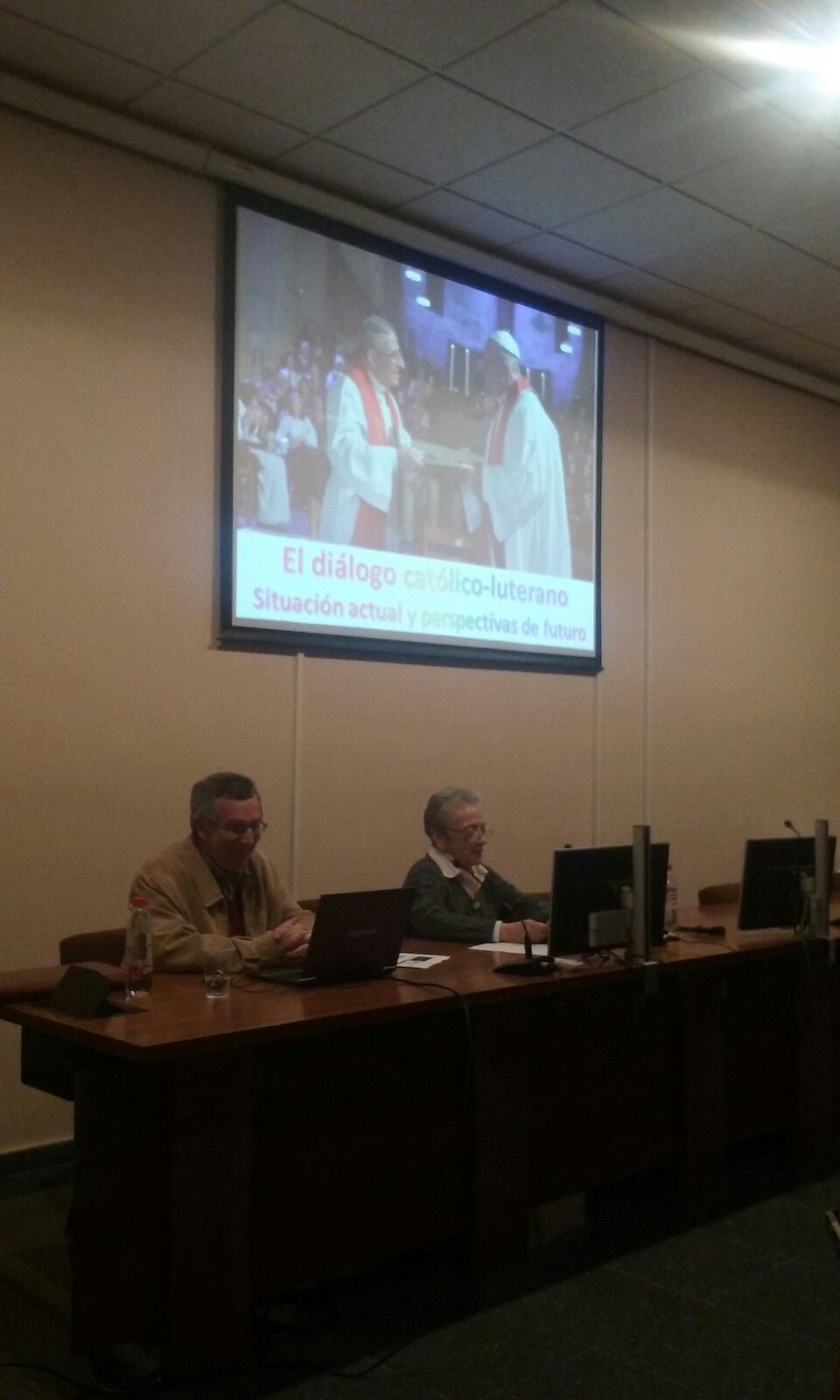 Imagen en la que se pueden ver a los ponentes de la segunda conferencia del ciclo de la reforma protestante, detrás de ellos hay una pantalla de proyección