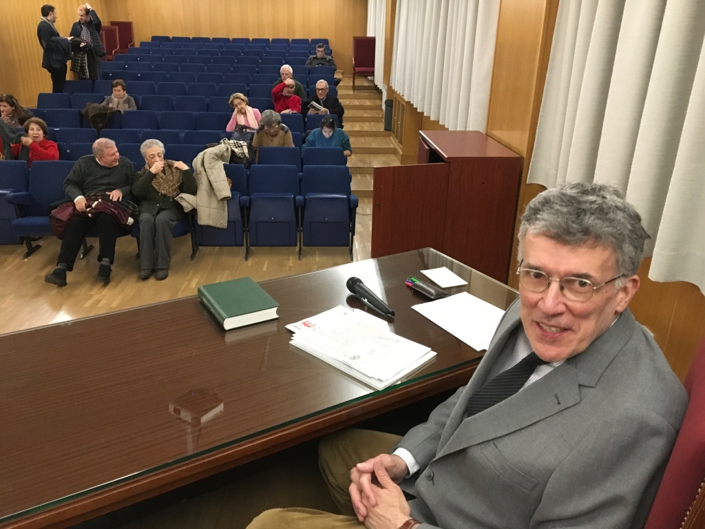 Imagen en la que se puede ver al profesor José María Margenat sentado, detrás de el se pueden ver los asistentes a la tercera conferencia del ciclo sobre la sociedad postsecular