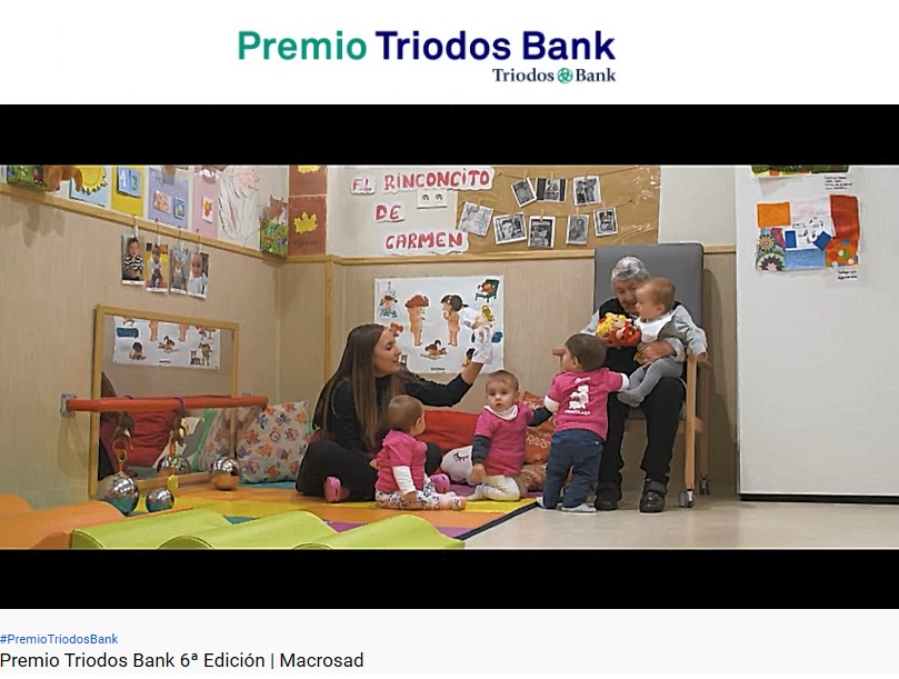 Imagen en la que se hace referencia al premio Triodos Bank, en ella se puede observar el trabajo de una educadora infantil junto a unos infantes